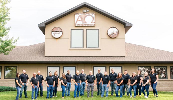Alpha Omega Disaster Restoration team stands in front of their office