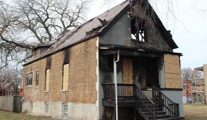 Boarded-up fire damaged house