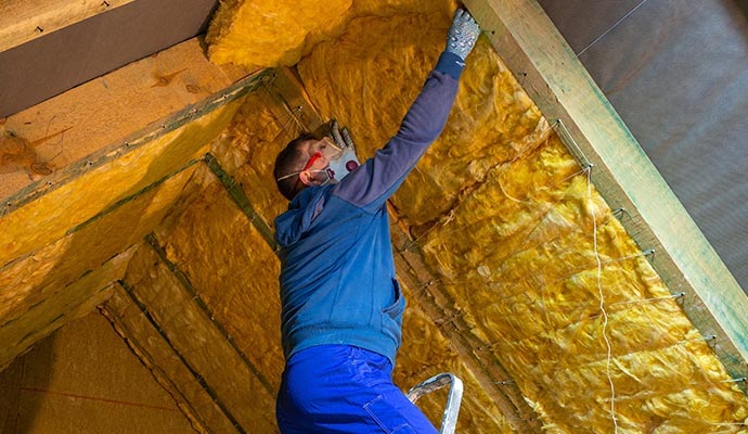A professional installing new insulation on roof